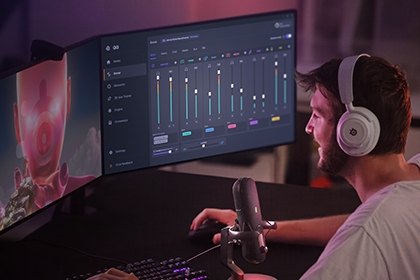 A gamer in a white tee uses the alias mic with Sonar settings in the background.